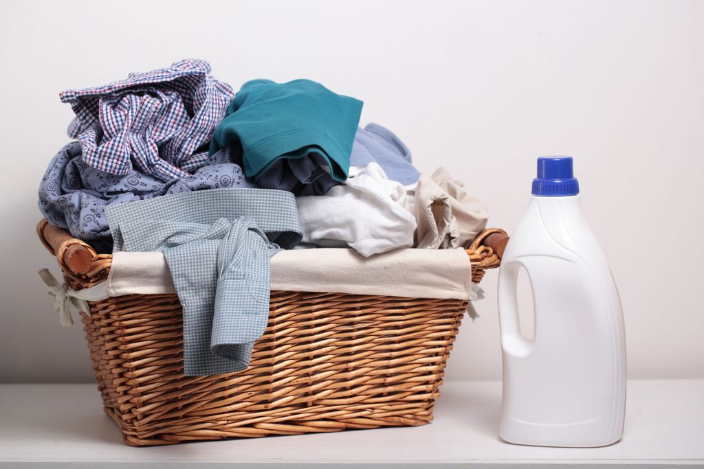 38735149 - dirty clothes in the laundry basket and a bottle of detergent