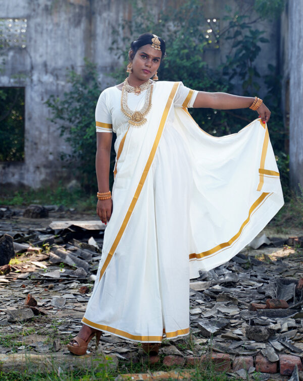 Saree-inspired dress with pleated skirt front, tailored mundhanai/pallu with sleeves, and double side pockets. Fabric: Handloom Cotton, Colour: Cream with gold jari border 1"